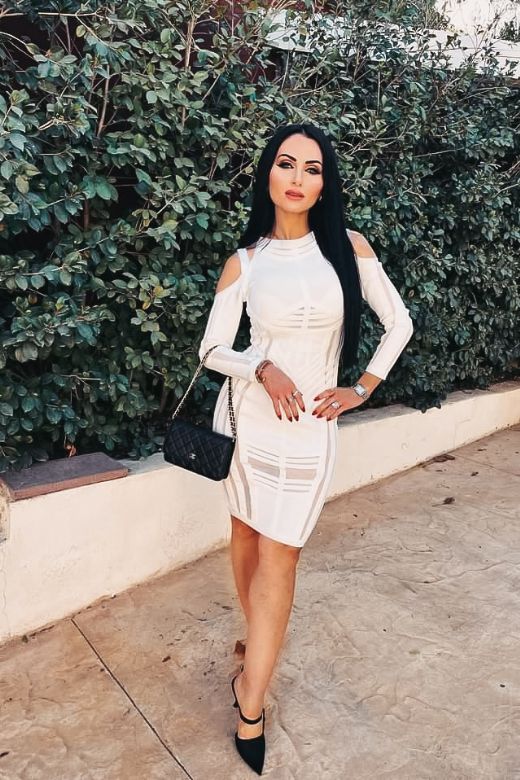 Woman wearing a figure flattering Amelia Long Sleeve Bandage Dress - Pearl White BODYCON COLLECTION