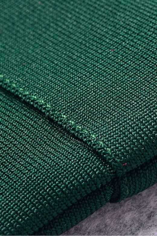 Woman wearing a figure flattering Josie Bandage V Neck Mini Dress - Emerald Green BODYCON COLLECTION